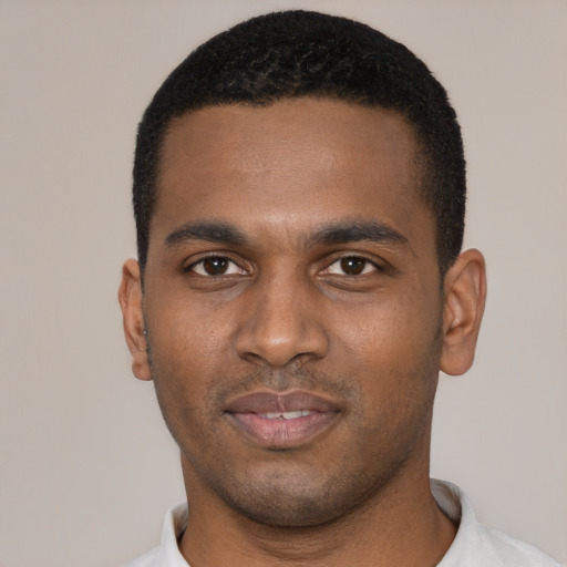 Joyful black young-adult male with short  black hair and brown eyes