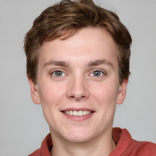 Joyful white young-adult male with short  brown hair and blue eyes