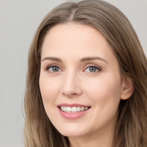 Joyful white young-adult female with long  brown hair and grey eyes