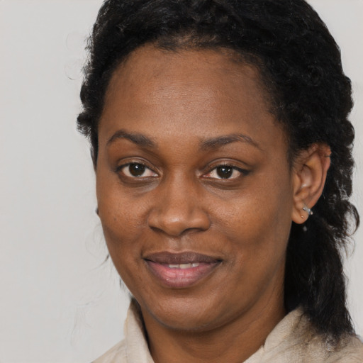 Joyful black young-adult female with short  black hair and brown eyes