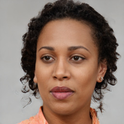 Joyful black adult female with medium  brown hair and brown eyes