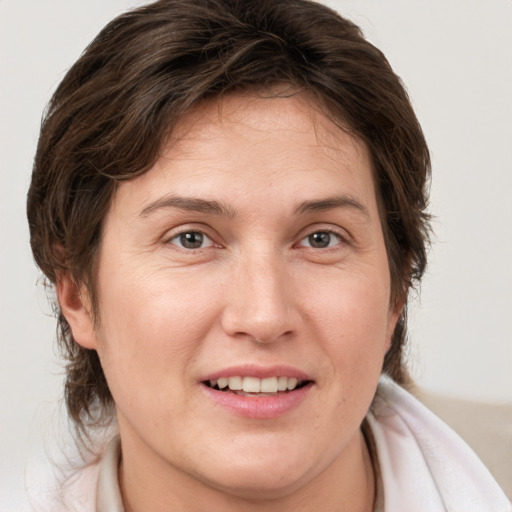 Joyful white adult female with medium  brown hair and brown eyes