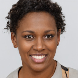 Joyful black young-adult female with short  brown hair and brown eyes