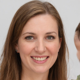 Joyful white young-adult female with long  brown hair and grey eyes