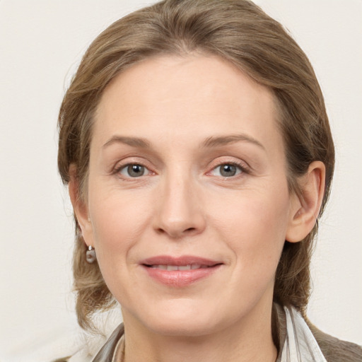 Joyful white young-adult female with medium  brown hair and grey eyes