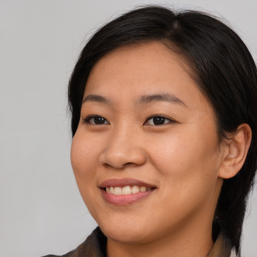Joyful asian young-adult female with medium  brown hair and brown eyes