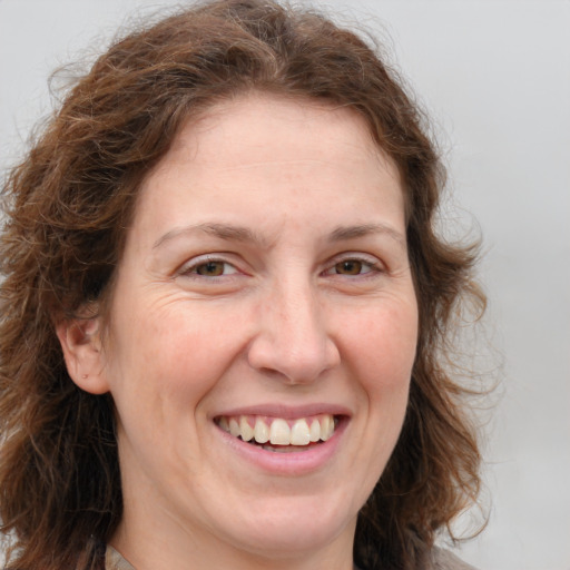 Joyful white adult female with long  brown hair and green eyes