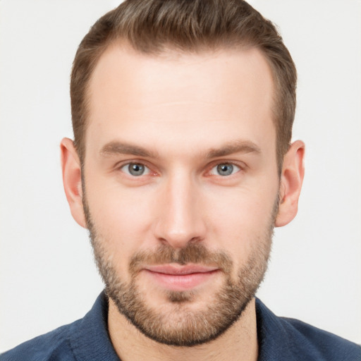 Joyful white young-adult male with short  brown hair and grey eyes