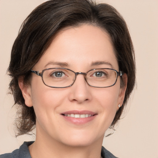 Joyful white adult female with medium  brown hair and grey eyes