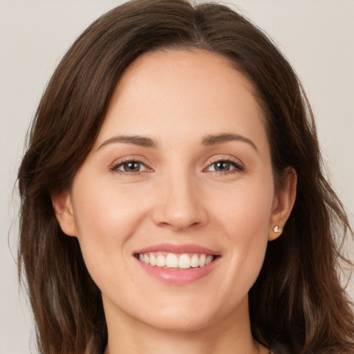 Joyful white young-adult female with long  brown hair and brown eyes