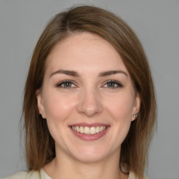 Joyful white young-adult female with medium  brown hair and grey eyes