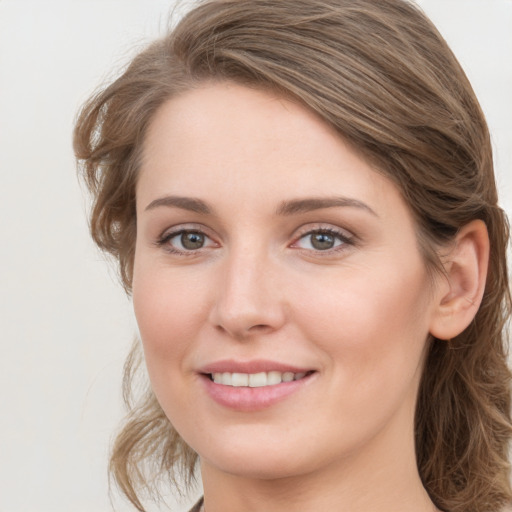 Joyful white young-adult female with medium  brown hair and grey eyes