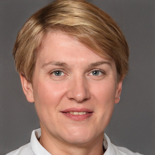 Joyful white adult female with short  brown hair and blue eyes