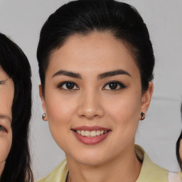 Joyful latino young-adult female with medium  brown hair and brown eyes