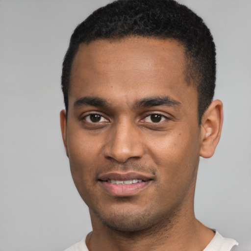 Joyful black young-adult male with short  black hair and brown eyes