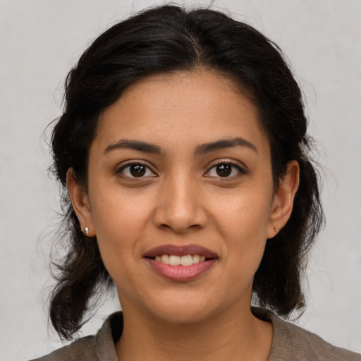 Joyful latino young-adult female with medium  brown hair and brown eyes