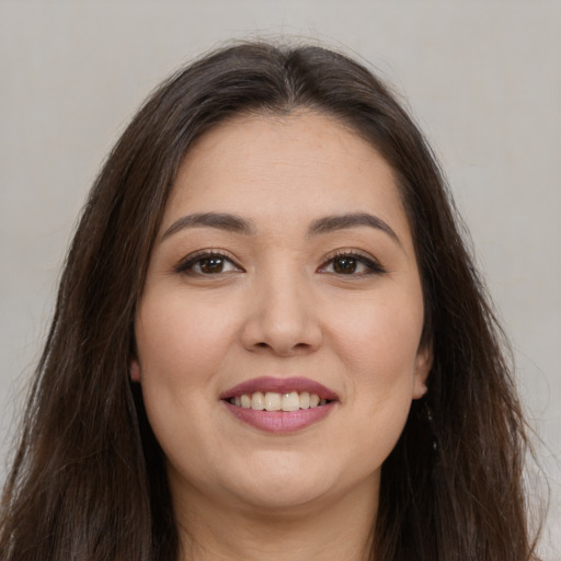 Joyful white young-adult female with long  brown hair and brown eyes