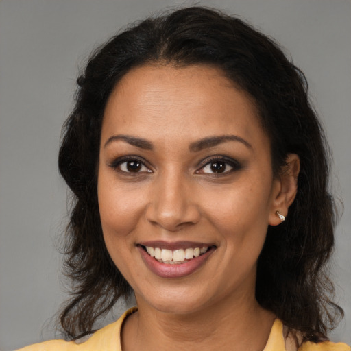 Joyful black young-adult female with medium  brown hair and brown eyes