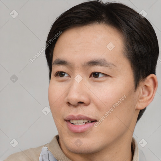 Joyful asian young-adult male with short  brown hair and brown eyes