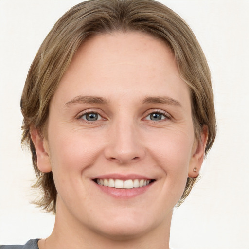 Joyful white young-adult female with medium  brown hair and green eyes