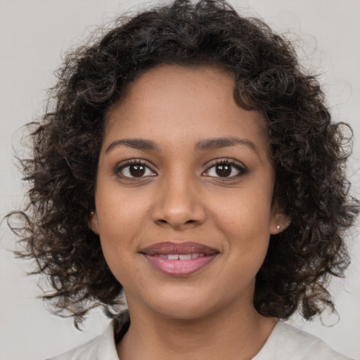 Joyful black young-adult female with medium  brown hair and brown eyes