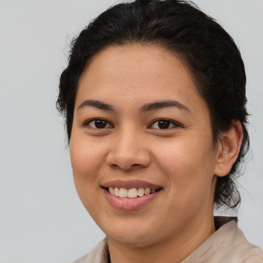 Joyful latino young-adult female with medium  brown hair and brown eyes