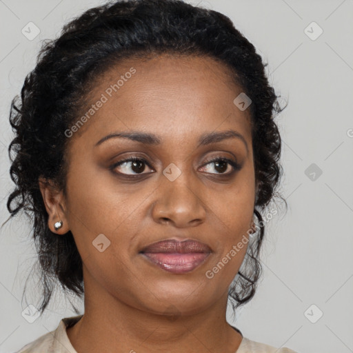 Joyful black adult female with long  brown hair and brown eyes