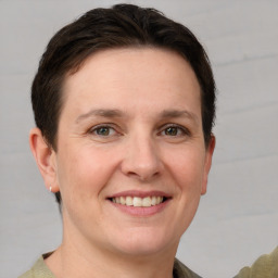 Joyful white young-adult female with short  brown hair and grey eyes