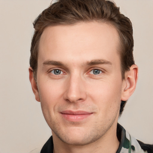 Joyful white young-adult male with short  brown hair and grey eyes