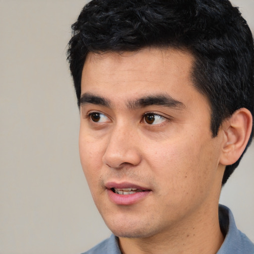 Joyful asian young-adult male with short  black hair and brown eyes