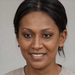 Joyful black adult female with medium  brown hair and brown eyes