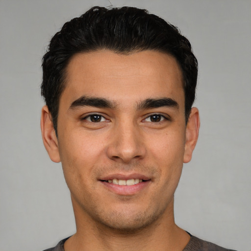 Joyful white young-adult male with short  black hair and brown eyes