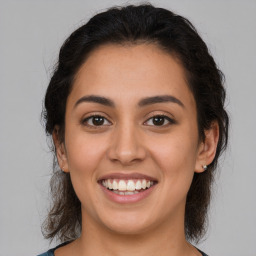 Joyful latino young-adult female with medium  brown hair and brown eyes