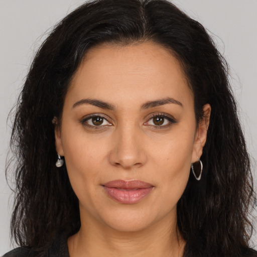 Joyful latino young-adult female with long  brown hair and brown eyes