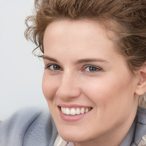 Joyful white young-adult female with short  brown hair and blue eyes