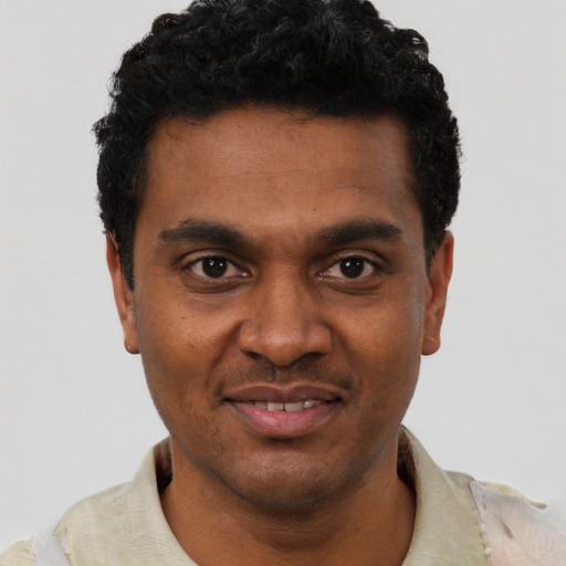 Joyful black young-adult male with short  black hair and brown eyes