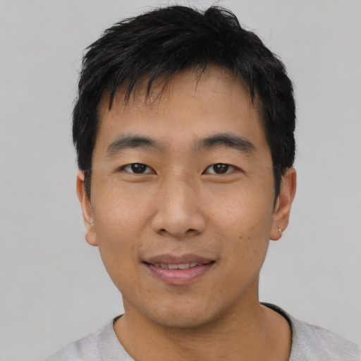 Joyful asian young-adult male with short  black hair and brown eyes