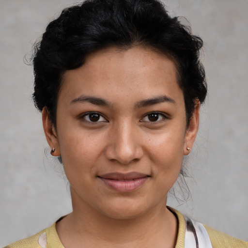 Joyful latino young-adult female with short  black hair and brown eyes