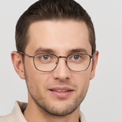 Joyful white young-adult male with short  brown hair and grey eyes