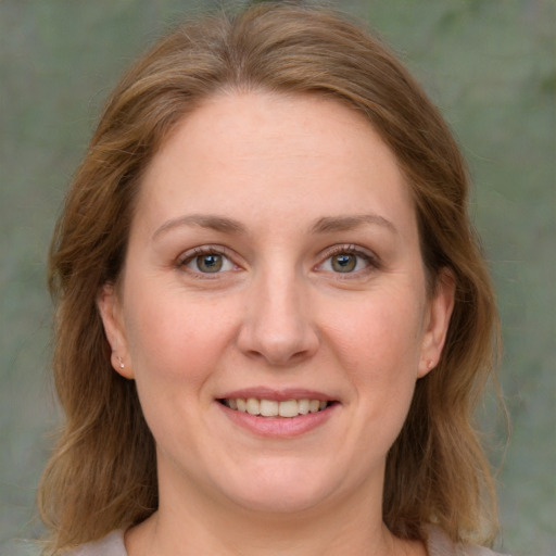 Joyful white adult female with medium  brown hair and green eyes