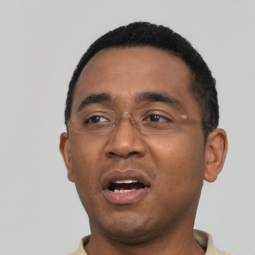 Joyful black young-adult male with short  black hair and brown eyes