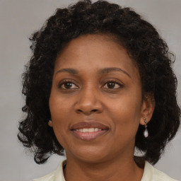 Joyful black adult female with medium  brown hair and brown eyes