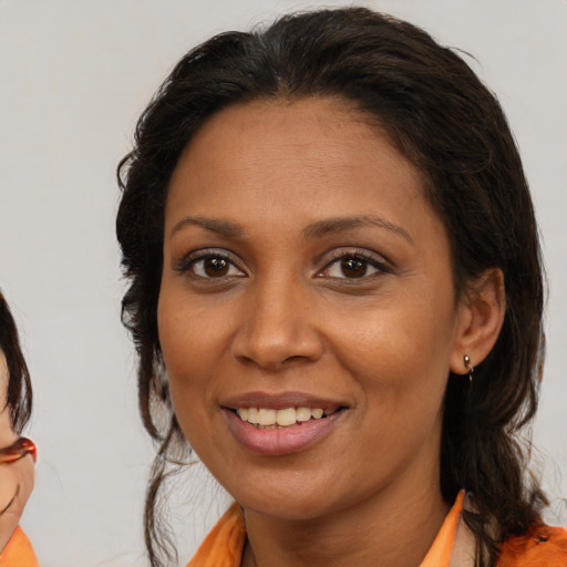 Joyful latino adult female with medium  brown hair and brown eyes