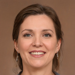 Joyful white adult female with medium  brown hair and grey eyes