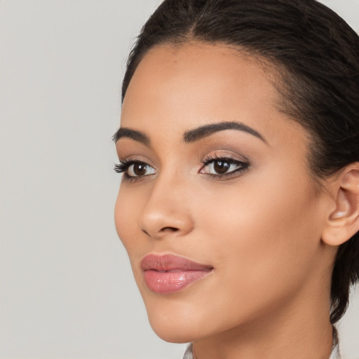 Joyful latino young-adult female with medium  brown hair and brown eyes