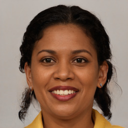 Joyful black adult female with medium  brown hair and brown eyes