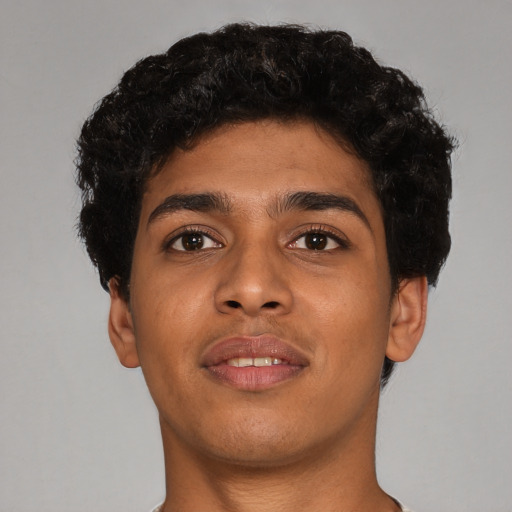 Joyful latino young-adult male with short  brown hair and brown eyes