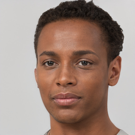 Joyful black young-adult male with short  brown hair and brown eyes