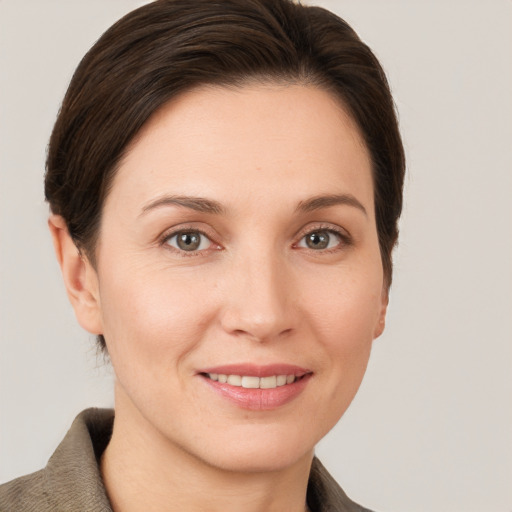 Joyful white young-adult female with short  brown hair and grey eyes