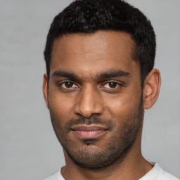 Joyful black young-adult male with short  black hair and brown eyes